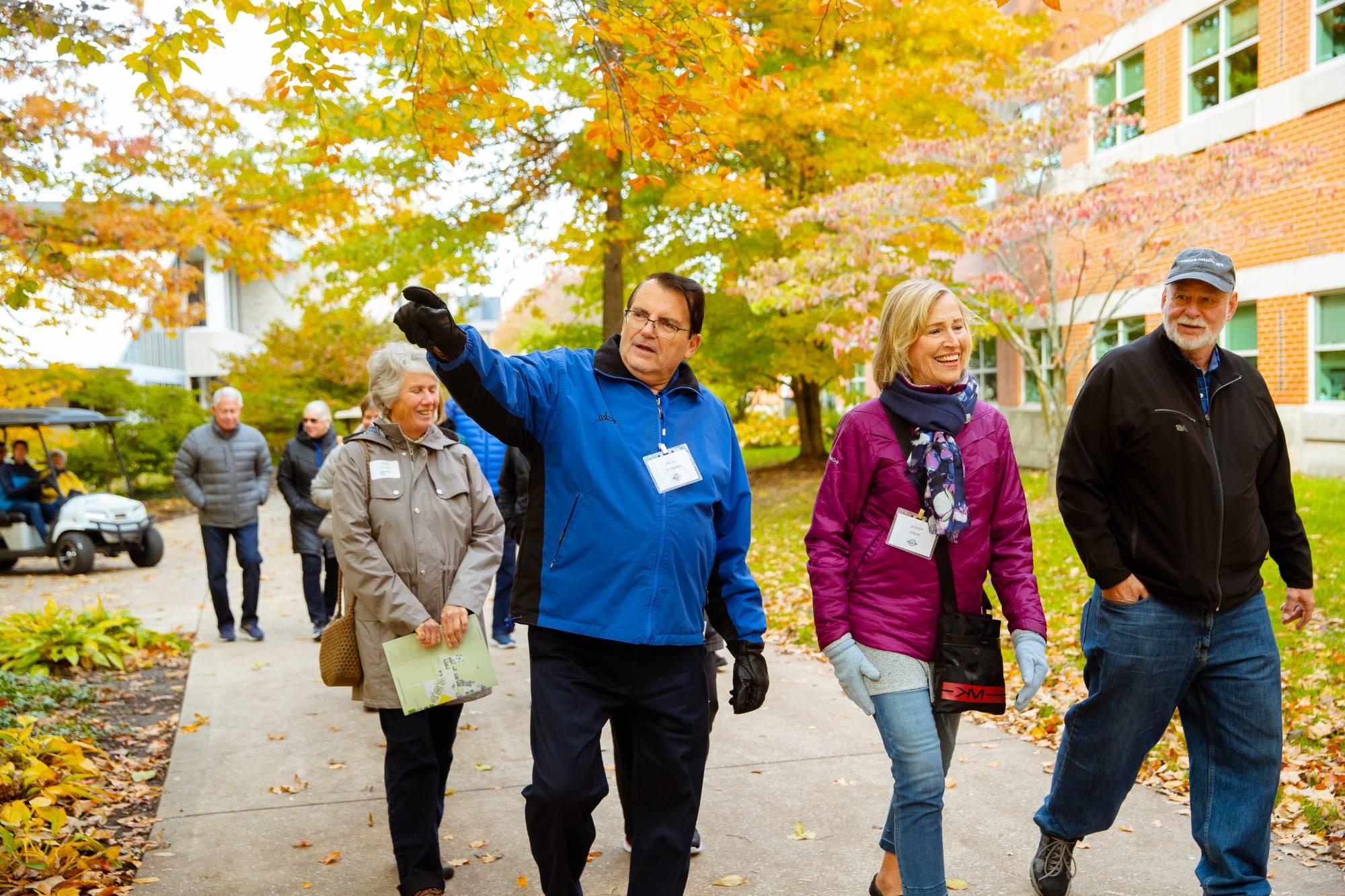 Alumni walk on campus during a guided campus tour